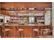 Stylish bar area featuring wood paneling, ample shelving, a large bar top, and comfortable seating at 4162 Club Course Dr, North Charleston, SC 29420