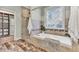 Bright bathroom features a soaking tub, walk-in shower with glass door, and decorative tile accents at 4162 Club Course Dr, North Charleston, SC 29420