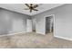 Spacious bedroom with grey walls, carpet flooring, ceiling fan, and two doors leading into other rooms at 4162 Club Course Dr, North Charleston, SC 29420