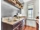 Wet bar featuring granite counters, stainless steel sink, storage, and wooden shelving with glasses and decor at 4162 Club Course Dr, North Charleston, SC 29420