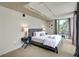 Bright bedroom with carpet, a large window, accent lighting, and a queen bed with stylish blue nightstands at 487 King St # 201, Charleston, SC 29403