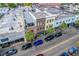 An aerial shot of downtown buildings and a street lined with palm trees and parked cars at 487 King St # 201, Charleston, SC 29403