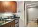 This kitchenette features wood cabinets, granite countertops, a toaster, and a mini fridge for added convenience at 487 King St # 201, Charleston, SC 29403