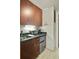 Convenient kitchenette equipped with wood cabinets, granite counters, a toaster, and mini fridge for guests at 487 King St # 201, Charleston, SC 29403