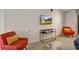 Cozy living room corner with vibrant red chairs, a sleek glass table, and a TV at 487 King St # 201, Charleston, SC 29403