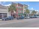 Street view of commercial buildings with palm trees and parallel parked cars at 487 King St # 201, Charleston, SC 29403