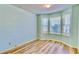 Comfortable bedroom featuring wood floors, soft blue walls, and large windows that provide plenty of natural light at 501 Hedge Way, Summerville, SC 29486