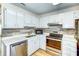 Well-equipped kitchen with stainless steel appliances, white cabinets, and stylish backsplash, perfect for cooking and entertaining at 501 Hedge Way, Summerville, SC 29486