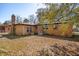 Brick house with a spacious, leafy backyard and chimney under a blue sky at 5520 Gale St, North Charleston, SC 29406