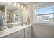 Bright bathroom with double sinks, a large mirror, and a window providing natural light at 624 Sienna Way, Summerville, SC 29486