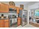 Kitchen with stainless appliances, wooden cabinets, granite counters, and access to the dining room at 711 Hemingway Cir, Summerville, SC 29483