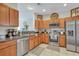 Eat-in kitchen features stainless appliances, wooden cabinets, granite counters, and tiled floors at 711 Hemingway Cir, Summerville, SC 29483