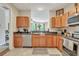 Eat-in kitchen features stainless appliances, wooden cabinets, granite counters, and tiled floors and leads to living room at 711 Hemingway Cir, Summerville, SC 29483
