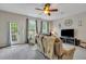 Living room with ceiling fan, large windows, carpeting, and comfortable seating at 711 Hemingway Cir, Summerville, SC 29483