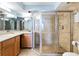 Bright bathroom featuring a glass shower, granite countertop, and warm wood cabinetry at 7600 Palmetto Drive # D-222, Isle of Palms, SC 29451
