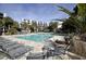 Resort pool with lounge chairs, umbrellas, palm trees, and condo buildings at 7600 Palmetto Drive # D-222, Isle of Palms, SC 29451