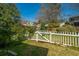 Backyard featuring green grass, mature trees, and a white picket fence at 7977 Shadow Oak Dr, North Charleston, SC 29406