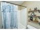 Bathroom with a shower/tub with blue curtain and wooden shelves at 7977 Shadow Oak Dr, North Charleston, SC 29406