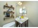 Bathroom featuring a white sink with a brown cabinet, a shelf with figurines and beauty products at 7977 Shadow Oak Dr, North Charleston, SC 29406