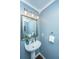 Bathroom featuring a white basin sink, framed mirror, modern lighting and blue walls at 7977 Shadow Oak Dr, North Charleston, SC 29406