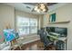 This is a bedroom with hardwood floors, a fan, and natural light coming through the window at 7977 Shadow Oak Dr, North Charleston, SC 29406