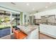 Bright kitchen featuring stainless appliances and granite island with bar stool seating and view of outdoor patio at 7977 Shadow Oak Dr, North Charleston, SC 29406