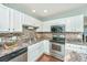 White kitchen with granite countertops and stainless steel appliances at 7977 Shadow Oak Dr, North Charleston, SC 29406