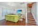 Bright and modern living room featuring hardwood floors, a TV, and staircase access at 7977 Shadow Oak Dr, North Charleston, SC 29406