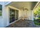 Covered patio featuring tiled flooring, ceiling fan, and glass sliding door at 7977 Shadow Oak Dr, North Charleston, SC 29406