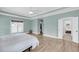 Bright bedroom with hardwood floors, ceiling fan, and view into the en-suite bathroom and walk-in closet at 8585 Refuge Pointe Cir, North Charleston, SC 29420