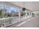 Spacious porch with white pillars and railings provides views of the neighborhood and swaying palm trees at 8585 Refuge Pointe Cir, North Charleston, SC 29420
