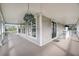 This porch features light grey floor, white pillars and railings and plants hanging from the roof at 8585 Refuge Pointe Cir, North Charleston, SC 29420