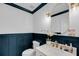 Elegant powder room featuring wainscoting, marble vanity, and designer fixtures at 8585 Refuge Pointe Cir, North Charleston, SC 29420