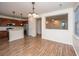 Open concept dining room featuring wood floors, stylish chandelier and adjacent kitchen area at 8849 Kellum Dr, North Charleston, SC 29420