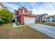 Charming red two-story home with a two car garage and well-maintained lawn at 8849 Kellum Dr, North Charleston, SC 29420