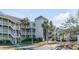 Well-maintained exterior of a multi-story condo building with palm trees and lush landscaping at 9000 Palmetto Dr # G-302, Isle of Palms, SC 29451