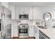 Modern kitchen with stainless steel appliances, white cabinets and backsplash, and bright countertops at 9000 Palmetto Dr # G-302, Isle of Palms, SC 29451