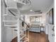 Bright living room featuring a spiral staircase, hardwood floors, and ample natural light at 9000 Palmetto Dr # G-302, Isle of Palms, SC 29451