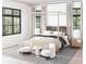 Stylish bedroom with large windows, a four-poster bed, and comfortable seating area at 925 Fish Camp Rd, Charleston, SC 29492