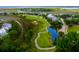 Picturesque golf course aerial featuring lush greenery, a pond, and surrounding neighborhood at 925 Fish Camp Rd, Charleston, SC 29492