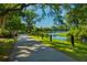 Paved walking path surrounded by trees, leading to a tranquil lake at 925 Fish Camp Rd, Charleston, SC 29492