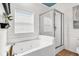 Bathroom with jacuzzi tub, shower, and a window with natural light at 94 W 2Nd St, Folly Beach, SC 29439