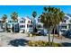 Coastal homes featuring garages, stairs, and palm trees in a picturesque neighborhood at 94 W 2Nd St, Folly Beach, SC 29439