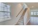 Bright staircase with carpeted steps, wood railing, and natural light from nearby windows at 103 Moscato Ln, Summerville, SC 29485