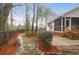 Landscaped backyard featuring a screened-in porch with access to a stone walkway and wooded surroundings at 109 Nelson Ct, Summerville, SC 29485