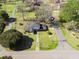 Aerial view of a home with a large yard, a trampoline, mature trees, and a driveway under a blue sky at 1115 O T Wallace Blvd, Moncks Corner, SC 29461