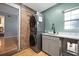 Cozy laundry room features a stacked washer/dryer, sink, brick accent wall, and wood floors at 1115 O T Wallace Blvd, Moncks Corner, SC 29461