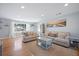 Sunlit living room boasts hardwood floors, neutral furniture, and a large window with bright natural light at 1115 O T Wallace Blvd, Moncks Corner, SC 29461