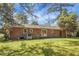 Rear exterior showcasing a brick facade, sliding glass doors, and a spacious grassy yard at 113 Harter Dr, Summerville, SC 29485