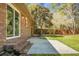 Landscaped backyard featuring a brick patio, mature trees, and a well-maintained lawn at 113 Harter Dr, Summerville, SC 29485